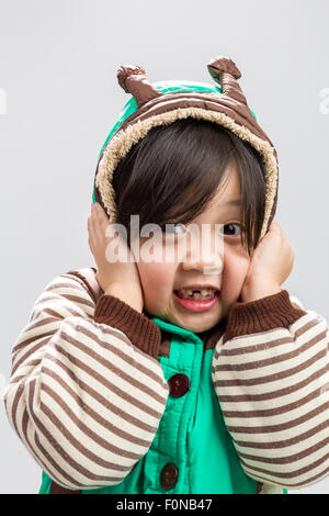 Carino ragazza asiatica brividi in cappotto, studio isolato sullo sfondo bianco. Foto Stock