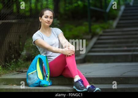 Ritratto di giovane donna sport dopo una seduta di allenamento sulle scale nel parco. Foto Stock