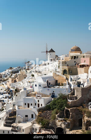 Case e Ville e il mulino a vento del villaggio di Oia come visto da Kasteli Castello, Santorini, Grecia Foto Stock