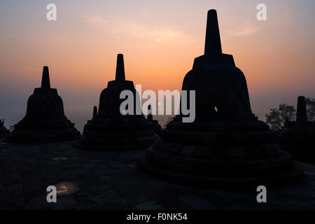 Silhouette di Stupa di sunrise al sito patrimonio mondiale dell'Unesco il tempio di Borobudur a Java, Indonesia, Asia. Foto Stock