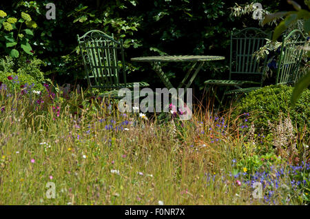 Area con posti a sedere in giardino prato disegnato da Squires Centro giardino. Foto Stock