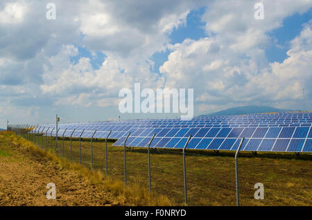 I lotti di pannelli solari dietro rusty il filo spinato nel campo vicino Sofia Foto Stock