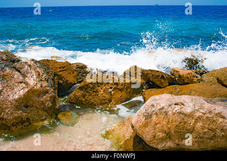 Costa rocciosa con spruzzi di acqua in Curacao Foto Stock