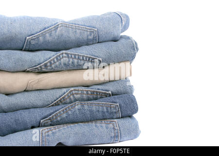 Pile impilate di jeans isolato su bianco Foto Stock