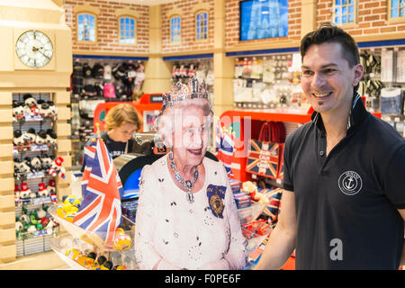 Divertente,royalty,i, Regina, saluta, turisti, al tourist shop outlet "glorioso Gran Bretagna' regali. Aerostazione partenze, l'aeroporto di Stansted, Londra,U.K. Foto Stock