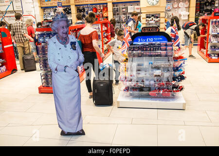 Divertente,royalty,i, Regina, saluta i turisti al tourist shop outlet "glorioso Gran Bretagna' regali. Aerostazione partenze, l'aeroporto di Stansted, Londra,U.K. Foto Stock