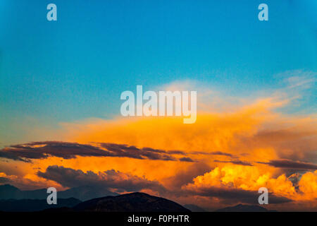 Una fiammante nuvola arancione al di sopra delle montagne di San Gabriel in California del Sud al tramonto Foto Stock