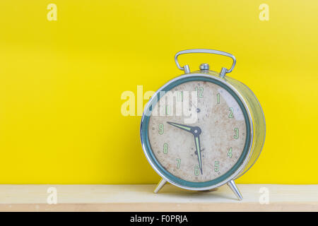 Il vecchio orologio di allarme sulla parete gialla. Foto Stock
