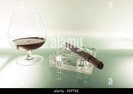 Con un bicchiere di brandy a base di cioccolato e un sigaro . Foto Stock