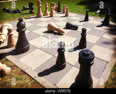 Partita scacchi a personaggi viventi bordo esterno con letto king size con dei pezzi di legno in una giornata di sole Foto Stock