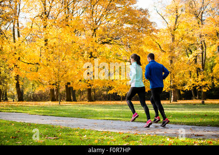 Coppia giovane jogging insieme nel parco - vista posteriore Foto Stock