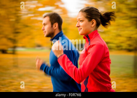 Il panning foto di coppia giovane jogging insieme in natura Foto Stock