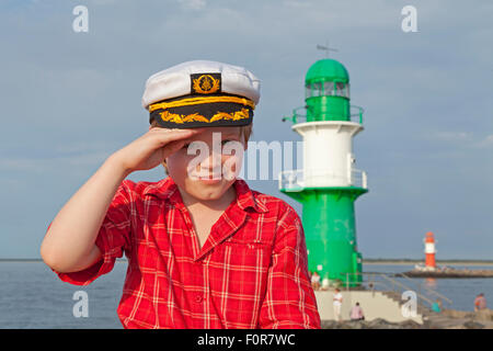 Giovane capitano salutando nella parte anteriore del faro, Warnemuende, Rostock, Meclemburgo-Pomerania Occidentale, Germania Foto Stock