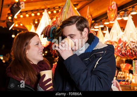 Paio di bere vino sul mercato di natale Foto Stock