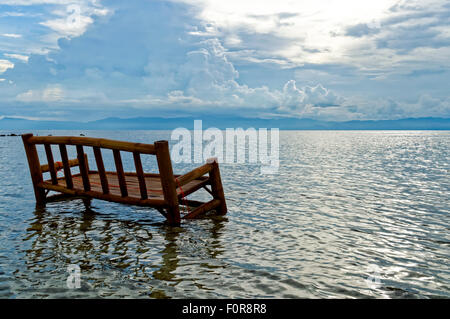 Una sedia di bambù è imbevuto nell'oceano Foto Stock