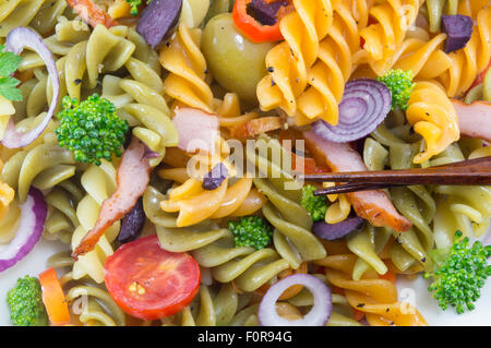 Maccheroni cucinato con verdure con verdure fresche servita con bacchette close up Foto Stock