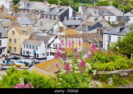Piccoli cottage cluster intorno all'affascinante porto peschereccio nel porto di Isacco, North Cornwall, England, Regno Unito Foto Stock
