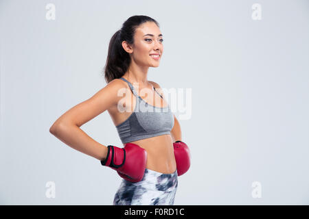 Ritratto di un sorridente sport donna in piedi nella boxe guanti isolati su sfondo bianco Foto Stock