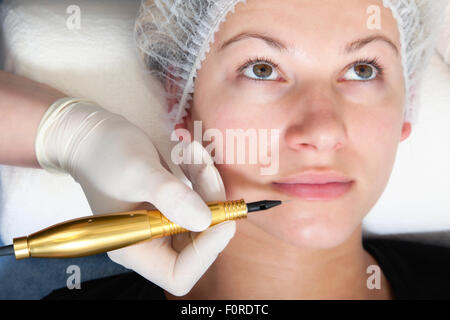 Cosmetologo rendendo trucco permanente sul volto di donna Foto Stock