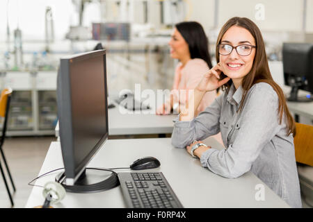 Giovane bella ragazza che lavora su un computer in un'aula Foto Stock