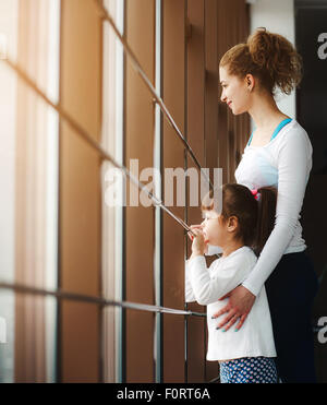 Due ragazze guardare nella finestra Foto Stock