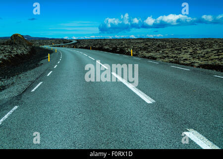 Autostrada 427 passando attraverso campi di lava nel sud dell'Islanda Foto Stock