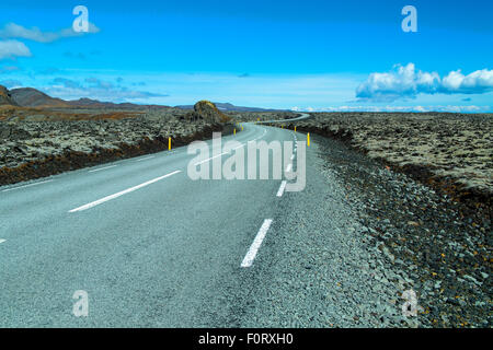 Autostrada 427 passando attraverso campi di lava nel sud dell'Islanda Foto Stock