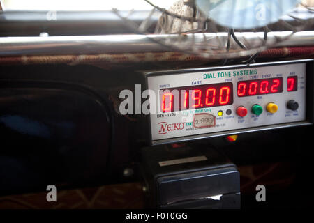 Cruscotto con un dispositivo di lettura del contatore in un taxi locale di Mumbai. Foto Stock