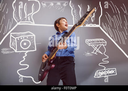 Teen boy a suonare la chitarra in camera sono oratori synth rock conc Foto Stock