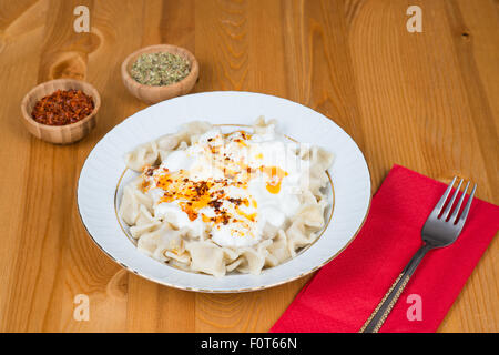 Bagno turco Manti (ravioli) sulla piastra con pepe rosso, burro, la salsa di yogurt e menta Foto Stock