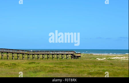 Il ponte sulla spiaggia, che si estende oltre le dune di sabbia e di erba. Golfo del Messico Ocean Beach Front situato a Galveston, Tx Foto Stock