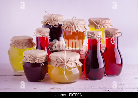 Conserve di frutta fatte in casa e marmellate ai frutti di bosco nel vaso del frullatore. Stile rustico. Messa a fuoco selettiva. Foto Stock