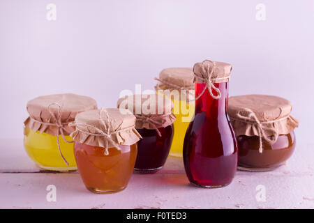 Conserve di frutta fatte in casa e marmellate ai frutti di bosco nel vaso del frullatore. Stile rustico. Messa a fuoco selettiva. Foto Stock