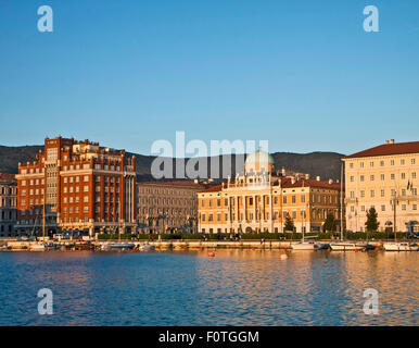 Trieste Italia - lungomare della città (Le Rive) sul tramonto con la vista del neo-classica facciata di Palazzo Carciotti Foto Stock