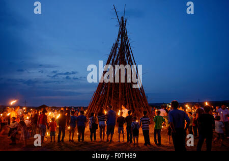 Persone in piedi intorno a un falò Sonnwendfeuer, Johannifeuer, Alta Baviera, Baviera, Germania Foto Stock