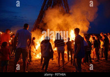 Persone in piedi intorno a un falò Sonnwendfeuer, Johannifeuer, Alta Baviera, Baviera, Germania Foto Stock