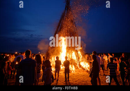 Persone in piedi intorno a un falò Sonnwendfeuer, Johannifeuer, Alta Baviera, Baviera, Germania Foto Stock