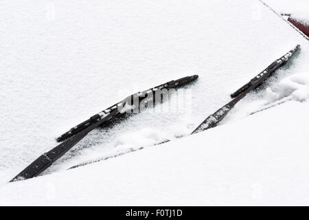 Primo piano di un'auto parabrezza e tergicristalli coperte di neve Foto Stock