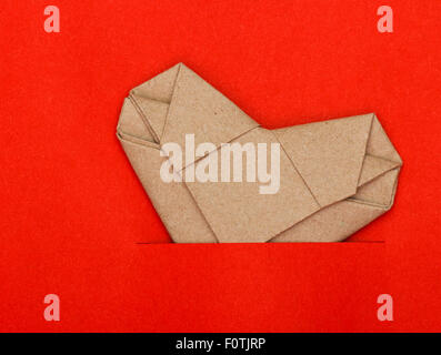 Origami riciclare carta cuore su carta rossa Foto Stock