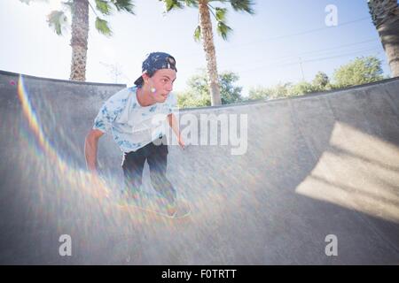 Giovane uomo skateboarding in parco, Eastvale, CALIFORNIA, STATI UNITI D'AMERICA Foto Stock