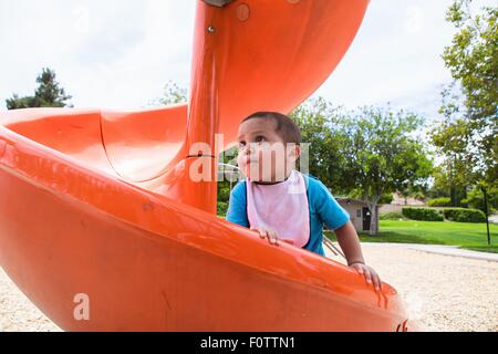 Maschio arrampicata toddler arancione parco giochi slitta Foto Stock