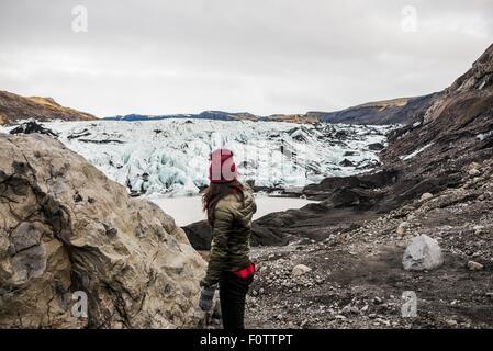 Turista femminile puntando al ghiacciaio Solheimajokull, Islanda Foto Stock