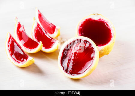La vodka jelly (jella) scatti fatti di limone scolpito su legno sbiancato tabella 1. Insolito adulto parte bevande Foto Stock