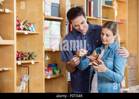 Giovane guardando a forma di stella decorazione in negozio Foto Stock