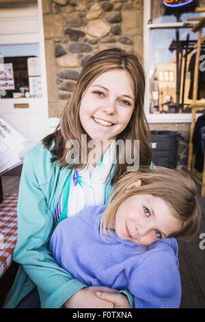Giovane donna e ragazza sorridente verso la telecamera, ritratto Foto Stock