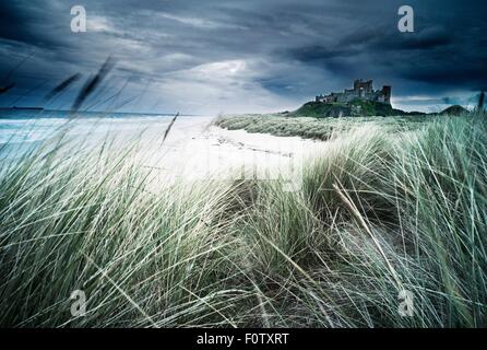 Vista del castello di Bamburgh e cielo drammatico, Northumberland, England, Regno Unito Foto Stock