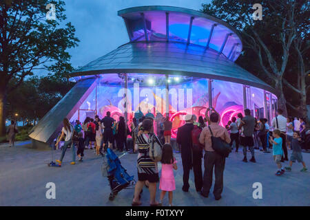 New York, NY, STATI UNITI D'AMERICA. 21 Ago, 2015. La Folla di entusiasti di adulti e bambini prendere passeggiate sul giorno di apertura della giostra SeaGlass in Battery Park di New York il giovedì 20 agosto, 2015. La nuova giostra ha 30 in fibra di vetro pesce luminescente per i visitatori di cavalcare e non vi è alcuna colonna centrale fornendo una vista senza ostacoli attraverso il pesce che si muove, il tutto accompagnato da un sottofondo di musica classica. A tre minuti di tragitto magico di imposta di $5. Credito: Richard Levine/Alamy Live News Foto Stock