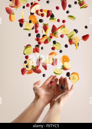 Le ragazze adolescenti mani la cattura di varietà di carni fresche a fette di frutta e bacche Foto Stock
