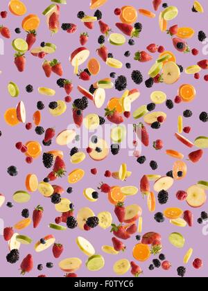 Fresca a fette di frutta e bacche su sfondo rosa Foto Stock