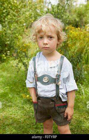 Ritratto di triste ragazzo con graffiato faccia indossando lederhosen Foto Stock